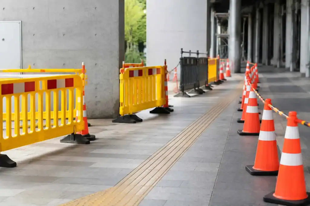 Orange traffic cones and striped safety barriers marking a construction work zone